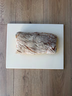 Loaf of bread on a white marble slab with a wooden floor background
