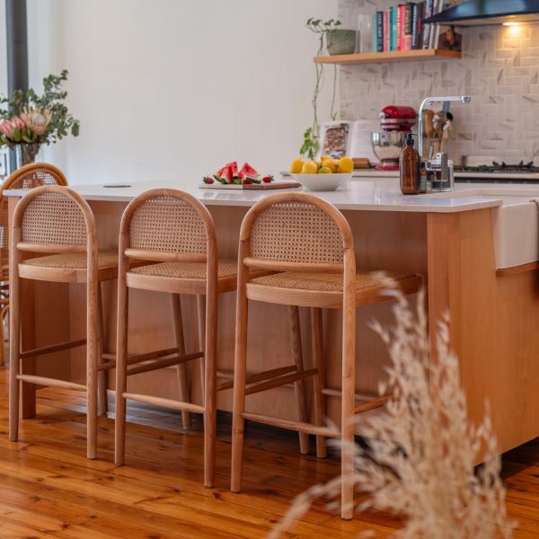 Kitchen with wooden island and bar stools, fruit on the counter