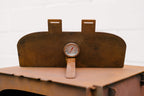 Rust-colored metal container with a pressure gauge on a white background
