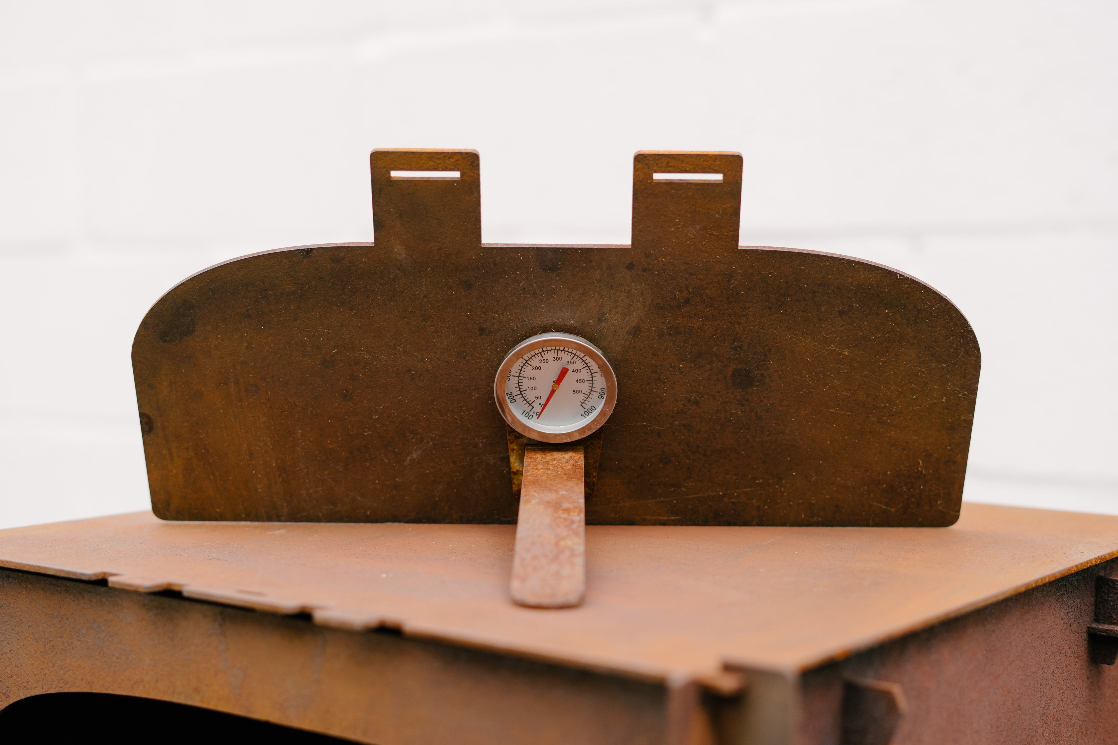 Rust-colored metal container with a pressure gauge on a white background