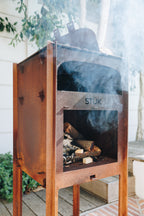 Wood-burning stove with 'STÜk' branding on a wooden deck.