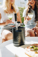 Portable beer tap with two people enjoying drinks in the background
